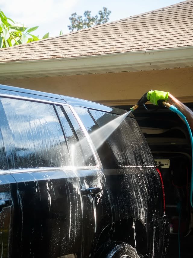 Detailer washing an SUV outside