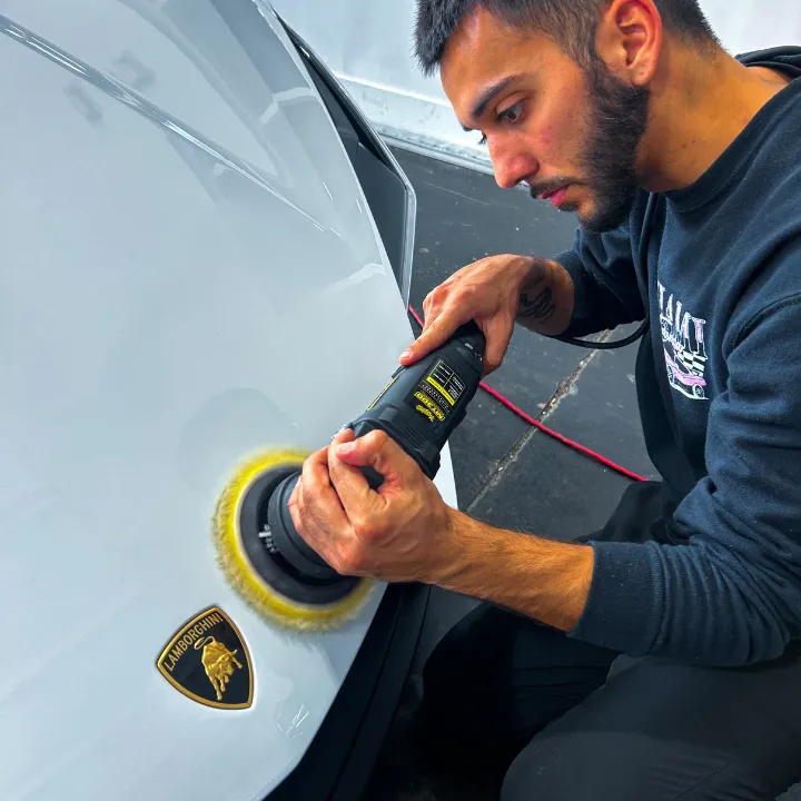 Detailer correcting the paint of Lamborghini